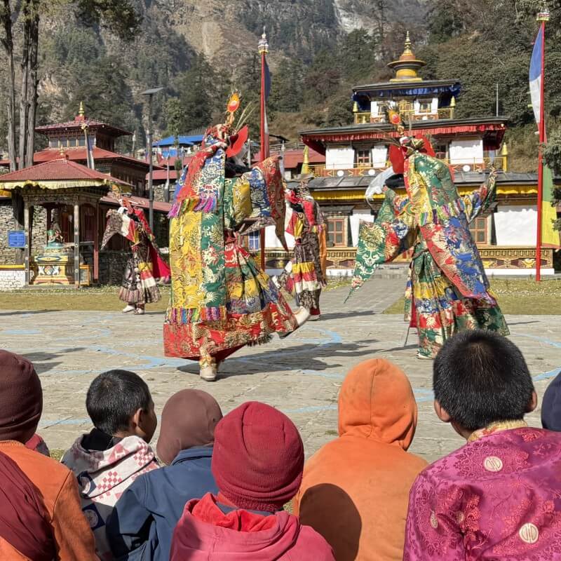 Junge Mönche verfolgen einen Maskentanz in der Serang Gompa